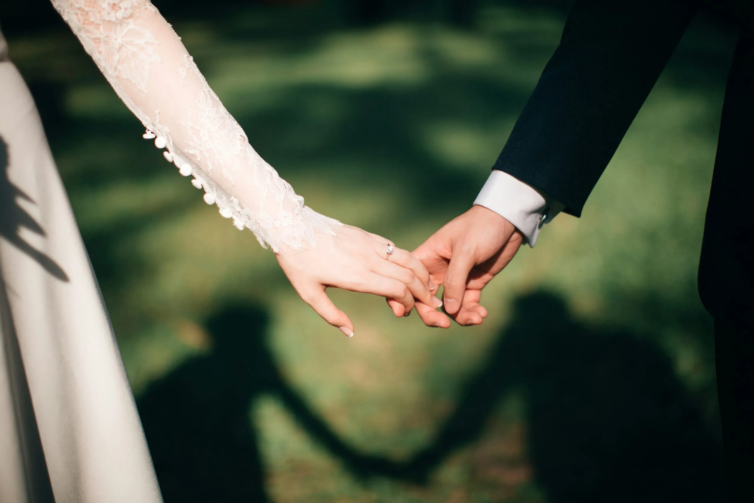 Couple holding hands on their wedding day.