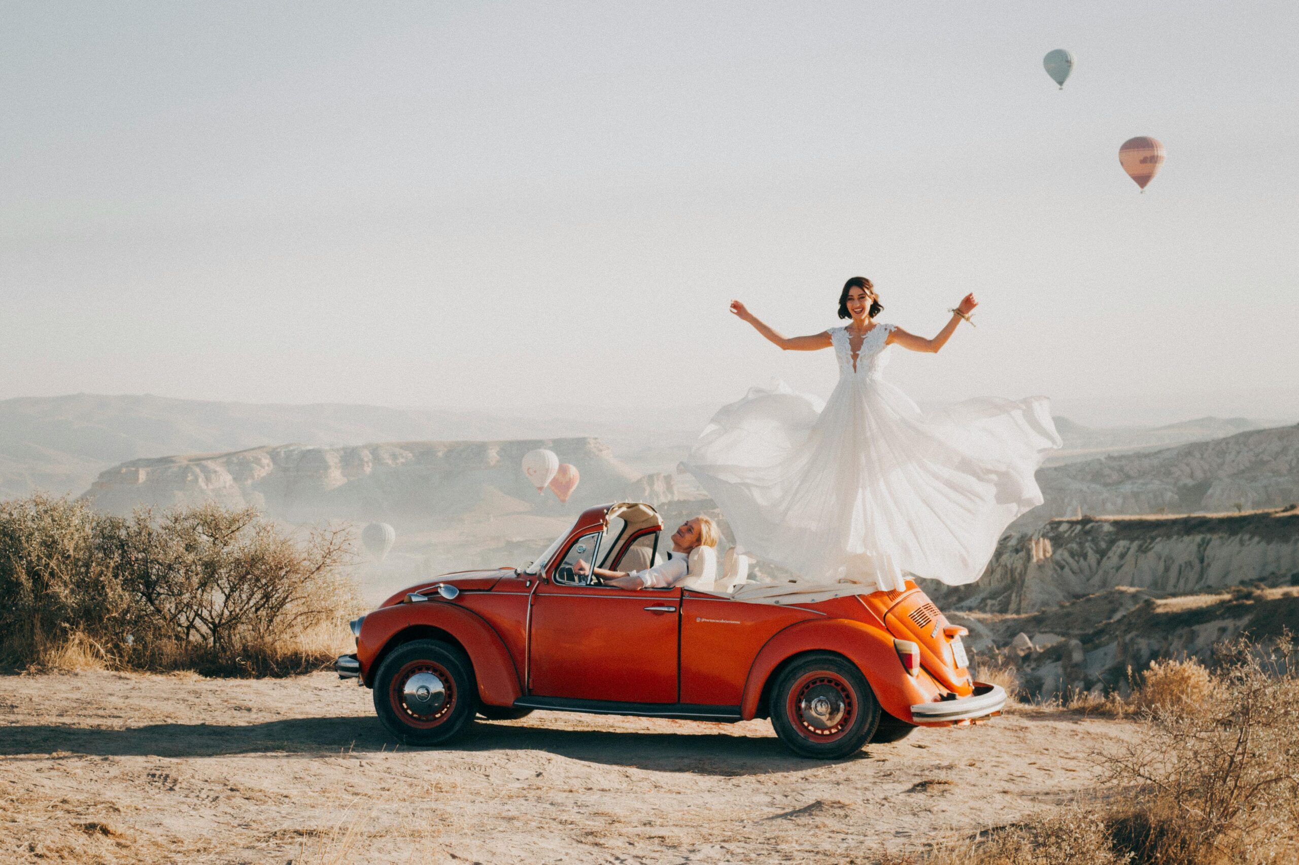 Bride on car in front of hot air balloons- Turkey