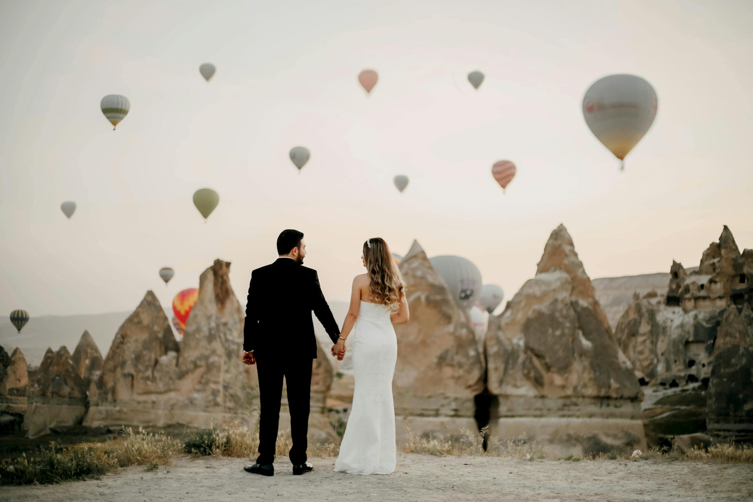 Couple in front of hot air balloons in turkey on their wedding day.