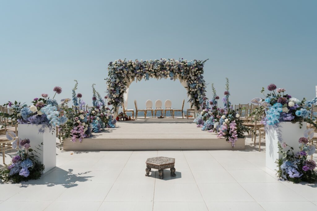 Blue and purple floral mandap on a seaside terrace prepared for a Hindu wedding ceremony in Turkey