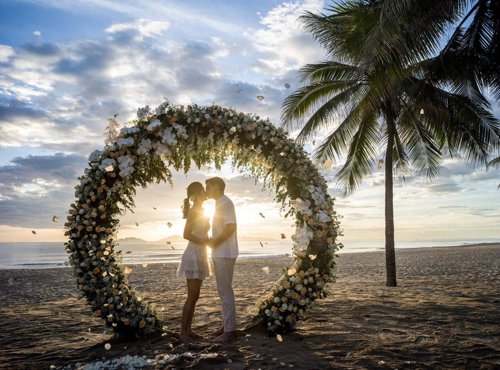 Couple kissing on beach with stunning sunset