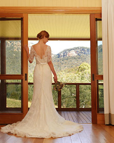 Bride staring outside of window balcony