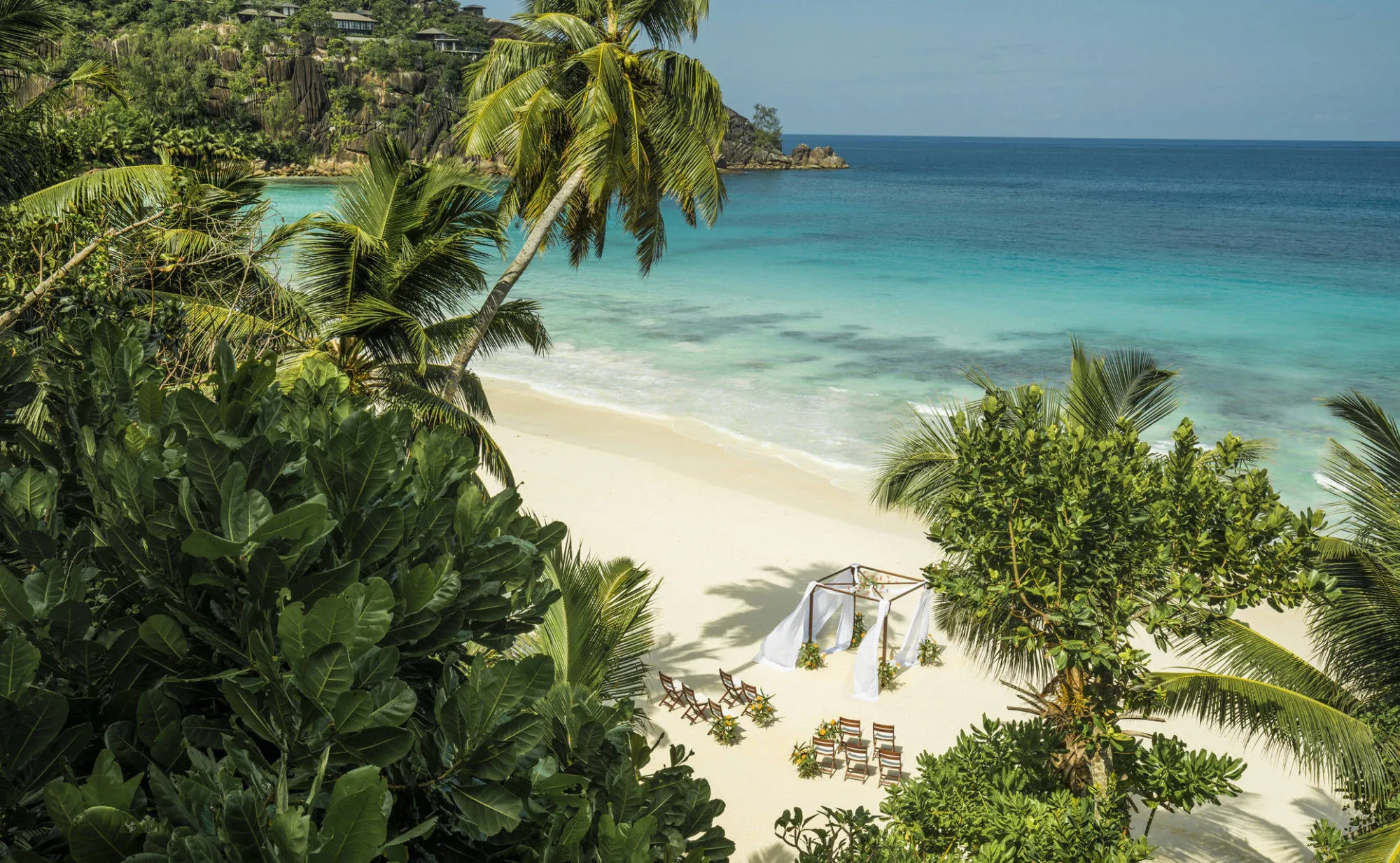 Beautiful sand beach with palm trees and turquoise sea at the Four Seasons Resort Seychelles