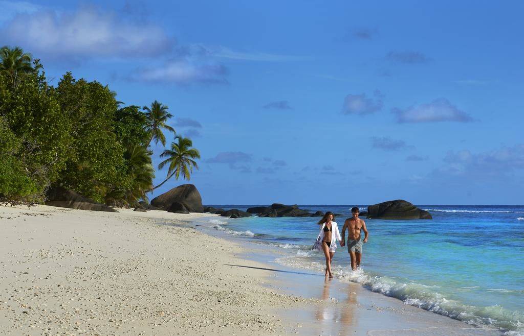 Beach with couple on at Hilton Seychelles Labriz Resort & Spa