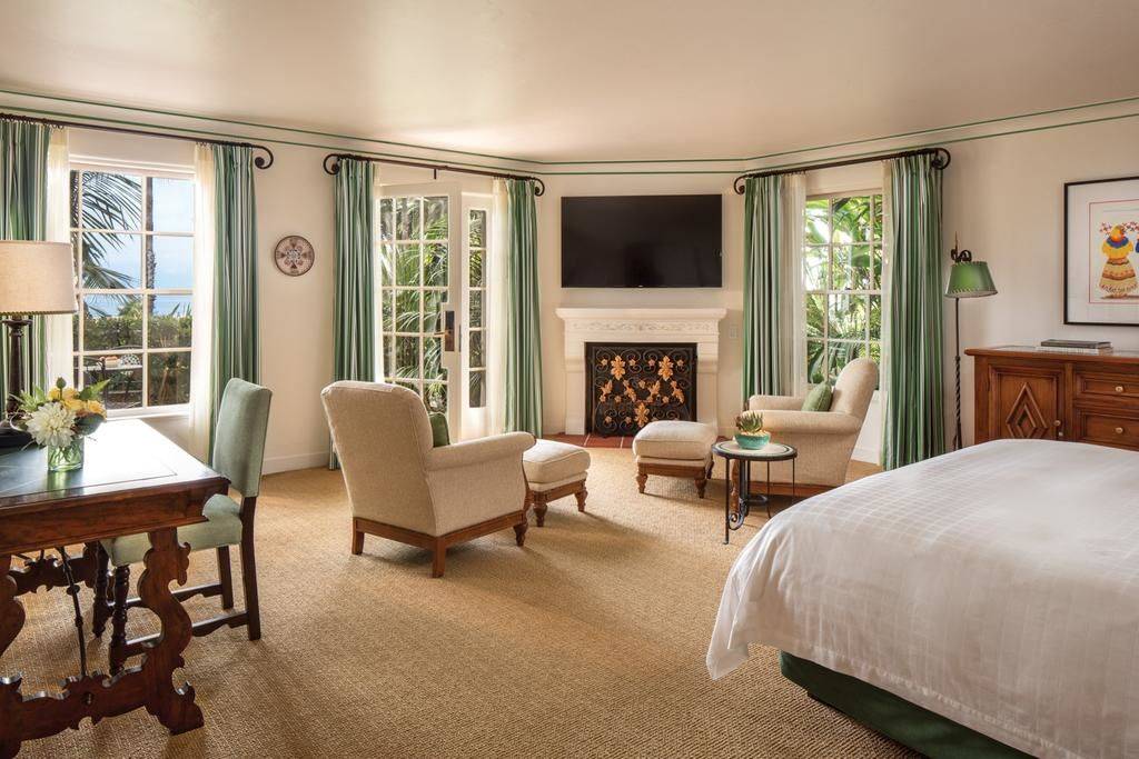 bedroom with a fireplace dining tables and living room at the Four Seasons Resort The Biltmore Santa Barbara