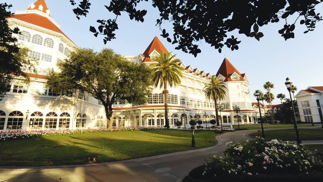 sunlit exterior of Disneys Grand Floridian Resort & Spa with lots of greenery around