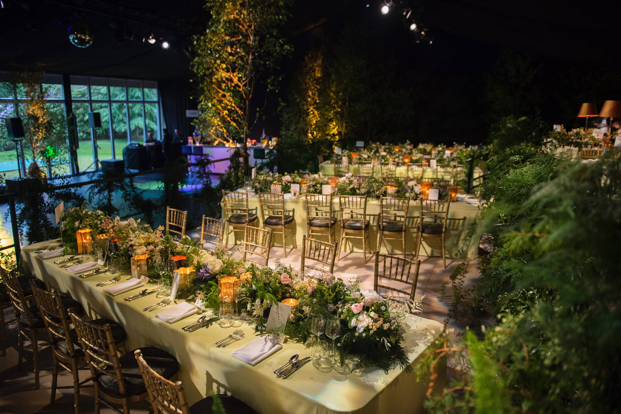 Long tables laid with lots of greenery and flowers