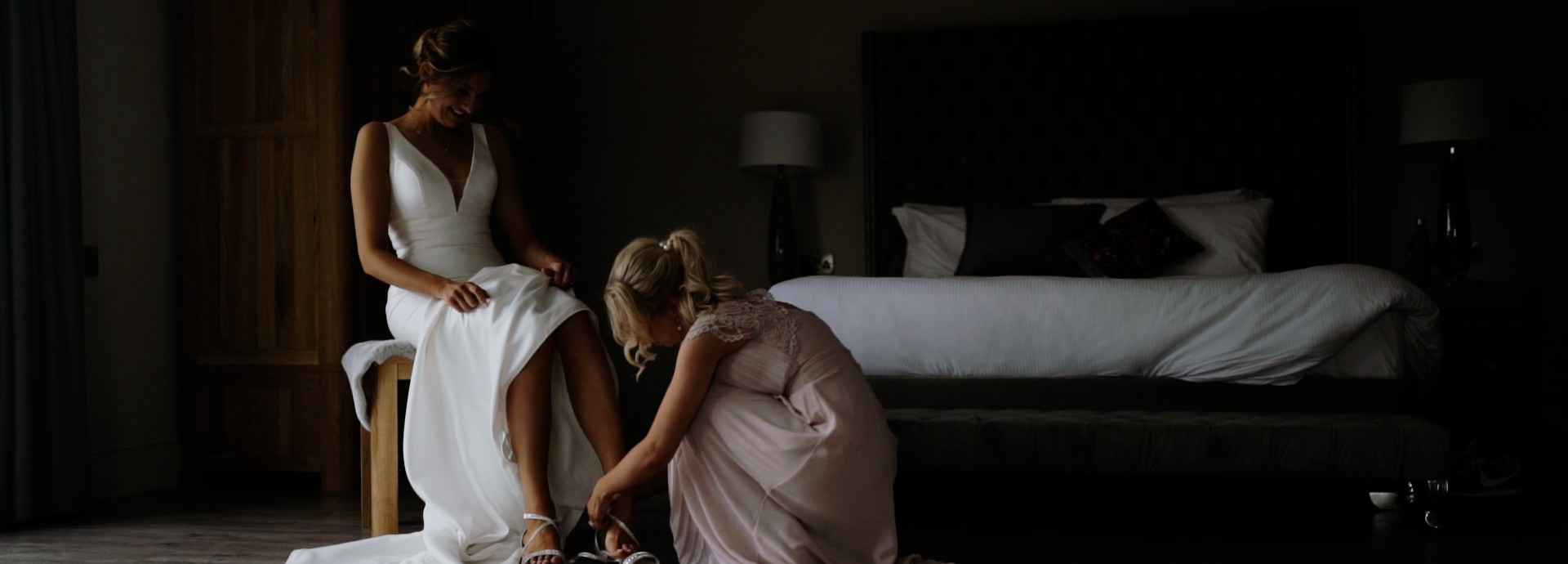 Bridesmaid helping a bride get ready for her wedding day