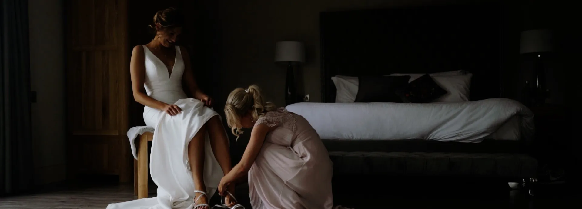 Bridesmaid helping a bride get ready for her wedding day